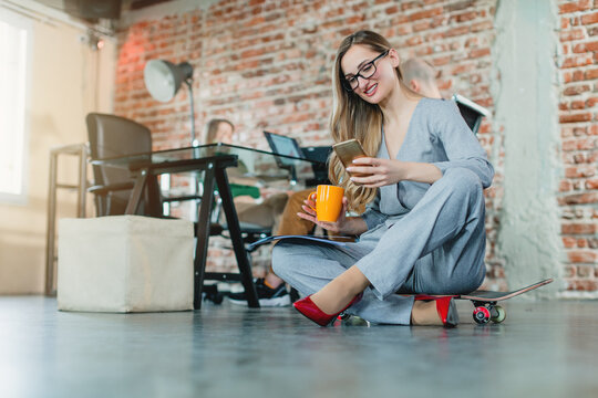 Woman in lofty office sitting on the floor working