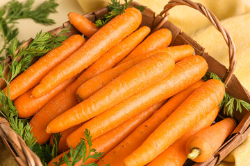 Wicker basket with fresh carrots, closeup