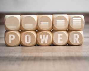 Cubes, dice or blocks with battery loading symbols and word power on wooden background