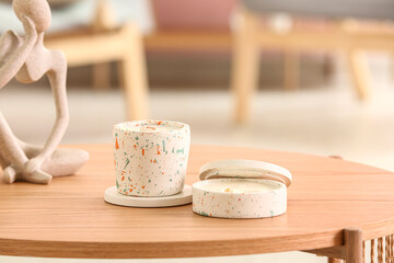 Holders with candles and decor on table in room, closeup