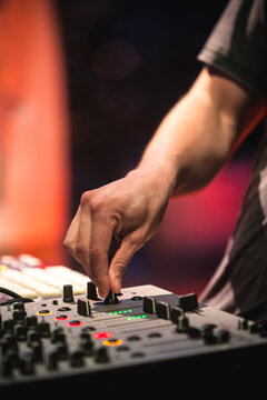 Close up view of a dj's hands playing the mixer while performing in a music festival. High quality photo