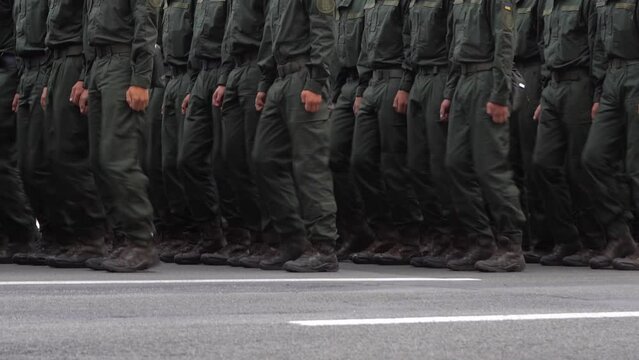 Military men marching in the parade. Soldiers legs. Boots forces and infantry soldier. Army march. Defender team. Crowd man go. Armed forces walking in a row. Uniform. War background.