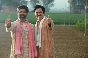 Beautiful composition of Happy Indian farmers standing together in the farm land. Farmer friends standing in the field.