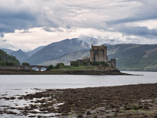 Eilean Donan Castle with bridge on a cloudy day - in Dornie, Scotland