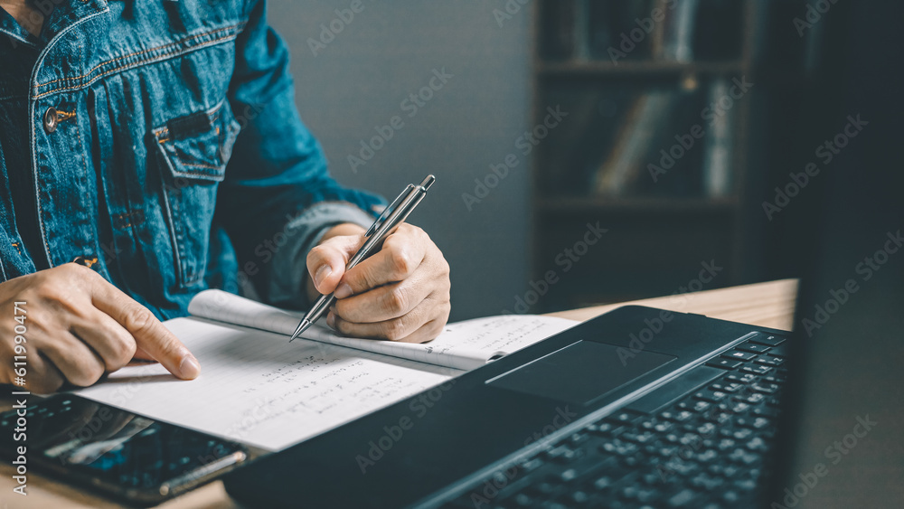 Poster man using smartphone and taking notes in planning. which is payment online, sits on the chair in the