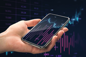 Close up of woman's hand holding smartphone with glowing candlestick index forex chart on blurry...
