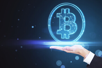Close up of businessman hand holding glowing blue bitcoin hologram on blurry bokeh circles background. Cryptocurrency and finance concept.