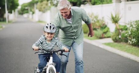 Happy, learning bike and a grandfather and child in the street for bonding, playing and childhood. Smile, family and an elderly man teaching a little boy kid to ride a bicycle with help in the road