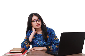 Tired Asian female in batik korpri, indonesian traditional working uniform working with laptop