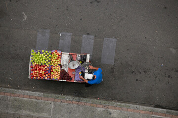 Trabajador informal latinoamericano vendiendo frutas 