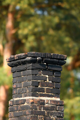 Stary brudny komin murowany z cegieł cały pokryty czarną sadzą 