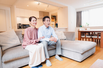 家でテレビを見るシニアの夫婦