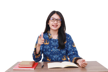 Asian female in batik korpri, indonesian traditional worker uniform pointing on you in office desk