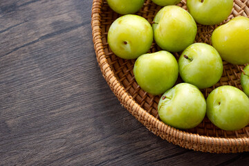 closeup of green plums in a basket