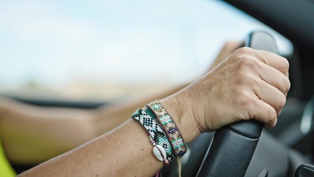 Middle age hispanic woman driving a car on the road