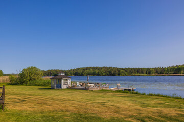 Fototapeta na wymiar Beautiful view of utility building on lake shore on sunny day. Sweden. Europe. 