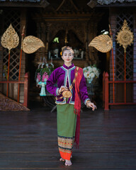 Fototapeta na wymiar Pretty Asian woman wearing ancient native Thai traditional dress costumes standing in the classic Thai house.