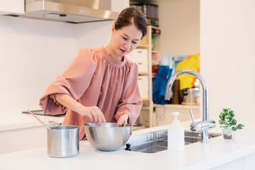 キッチンで料理をするシニアの女性