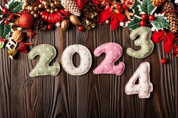 Colorful stitched digits 2024 of polkadot fabric with Christmas decorations flat lay  background on wooden table