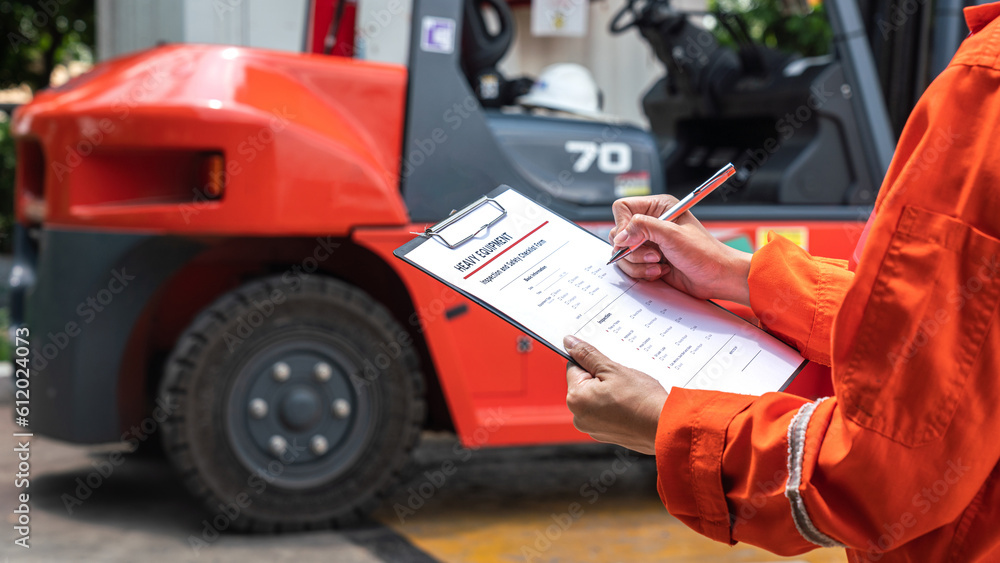Wall mural a mechanical engineer is using heavy equipment checklist form for inspecting the factory forklift ve