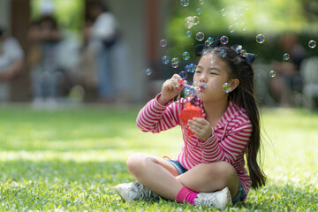 Asian girl playing with a bubble machine.