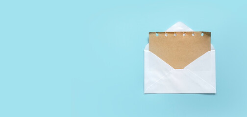 Greeting card or invitation mailing concept.Brown paper from an open white envelope. Template for mockup with copy space.