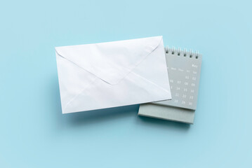 A white envelope over a calendar on a blue background.