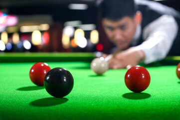Snooker black one ball and snooker player with competitor blur while aiming black ball on snooker...