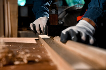 Close-up the hand of carpenter craftsman making pool cue or snooker cue with a manual hand wood planer in carpentry workplace. Handmade craftsman concept. Focusing on hand wood planing.