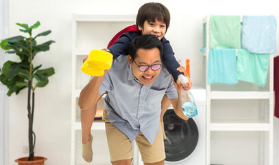 Portrait of enjoy happy love asian family father carrying little asian boy son smiling playing superhero and having fun.happy family and father's Day in moments good time at home