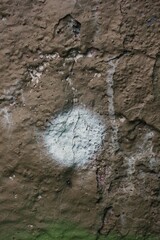 An old concrete wall with a white dot.