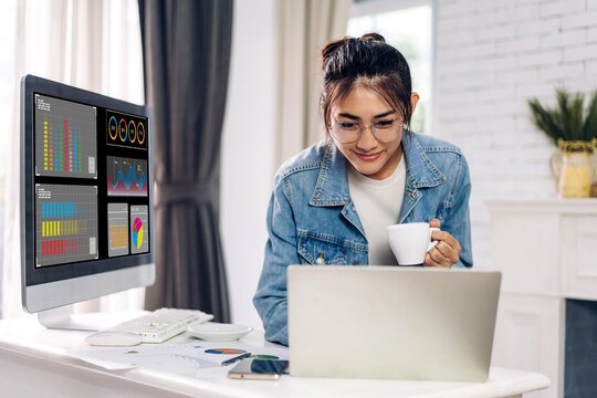 Young smiling asian woman relax using laptop work, analyzing data management system and make report with KPI, strategy, finance, sales, marketing, money, business growth, financial investment graph