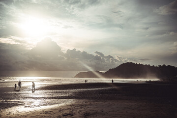 Naklejka na ściany i meble beach sunset with people walking