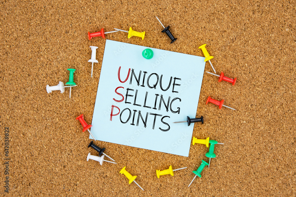 Poster unique selling points text on light blue post-it paper pinned on bulletin cork board surrounding by 