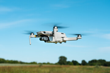 Fototapeta na wymiar Drone in flight against the background of the field and sky