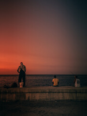 Fototapeta premium Fishermen working during sunset on Havana Malecón