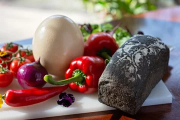 Zelfklevend Fotobehang Homemade bread, ostrich egg and vegetables, paprika, tomatoes, chili, onion, salad. Ingredients for making an omelet, shakshuka. Soft selective focus. © Tasha Sinchuk