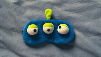 Sleeping mask and sleep icon on soft bed sheet. Funny sleeping mask. Bedtime concept. High angle...