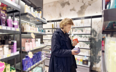 buying make up at cosmetics section in store. choosing cosmetics, perfumes, creams and shampoos, Using tester.