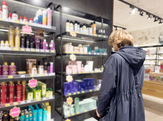 buying make up at cosmetics section in store. choosing cosmetics, perfumes, creams and shampoos, Using tester.