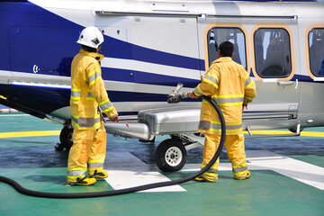 Helicopter Landing Officer communicating with pilot and copilot for service on ground and support as the pilot required. The helicopter landing on the deck and service by ground service team.