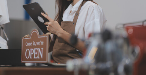 Welcome. Open. barista, waitress woman turning open sign board on glass door in modern cafe coffee shop ready to service, cafe restaurant, retail store, small business owner, food and drink concept