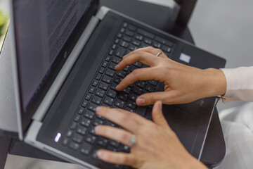 women's hands lying on laptop keyboard. a woman's hand with a watch 