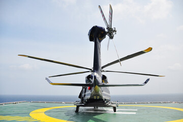 Helicopter Landing Officer communicating with pilot and copilot for service on ground and support as the pilot required. The helicopter landing on the deck in oil and gas platform
