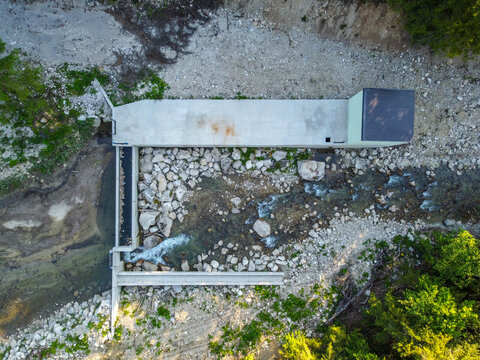 Mini hydroelectric power plant. MHE. Concrete dam on the river.
