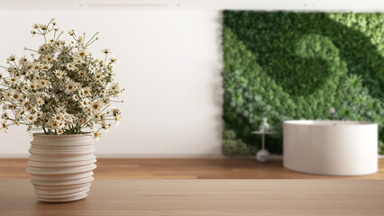Wooden table top or shelf with pottery vase with daisies, wild flowers, over bathroom with vertical garden in minimal style, modern interior design concept
