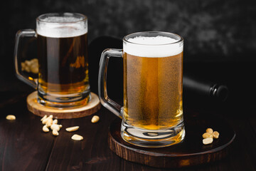 Mugs of lager beer and salty nuts. oktoberfest atmosphere, craft brewery background