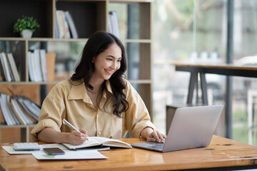 Asian woman working with laptop in her office. business financial concept.