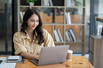 Asian woman working with laptop in her office. business financial concept.