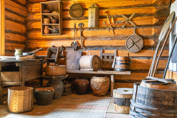 The interior of the kitchen in an old village house built in the 19th century. Household items of the 19th century in the village. Kitchen utensils made of wood. Kitchen in a wooden house made of logs